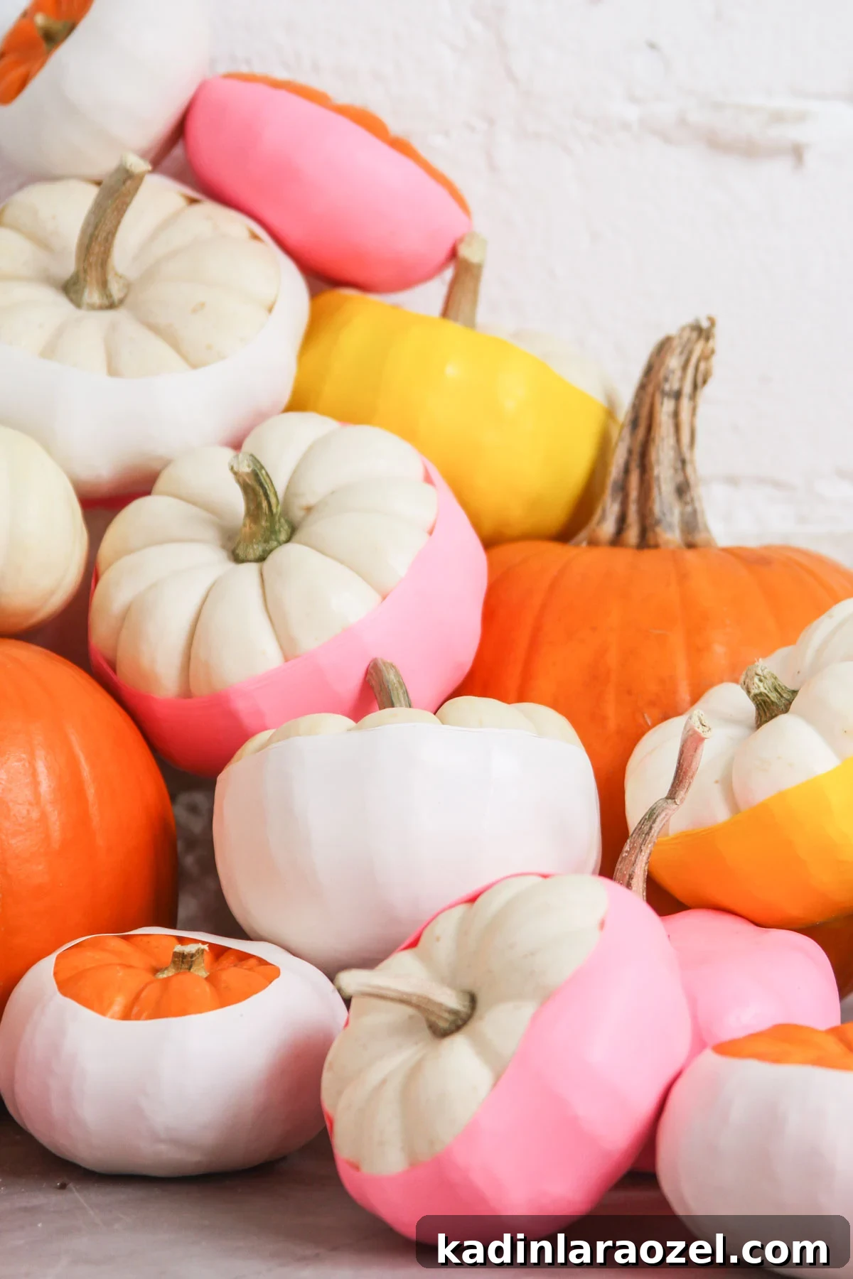 Colorful small pumpkins, decorated in warm colors, like pink and yellow.
