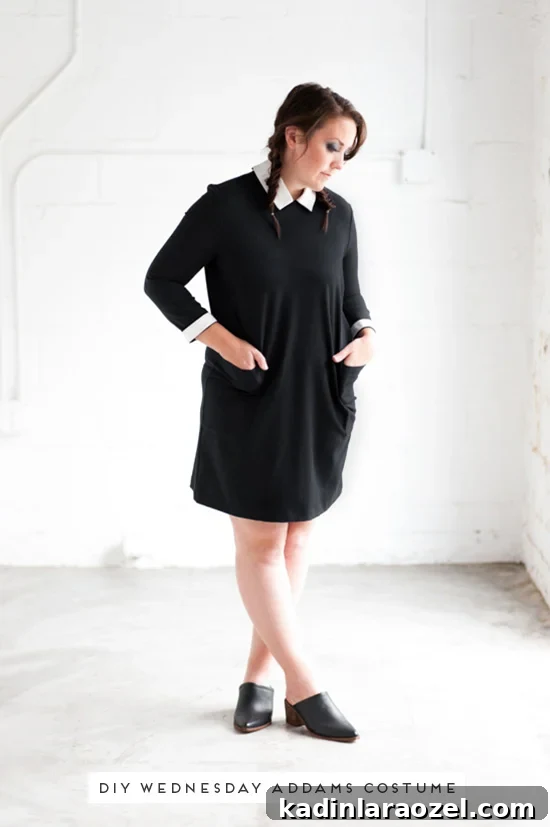 Woman wearing a Wednesday Addams Halloween costume with black and white dress.