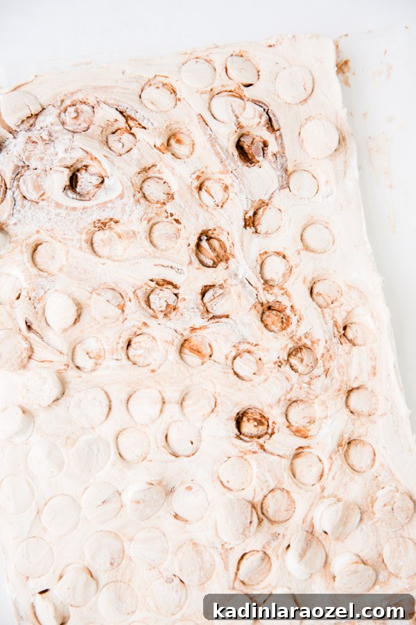 Marbled Nutella marshmallows after they have been cut into small circles, but haven't been removed from the marshmallow sheet yet.