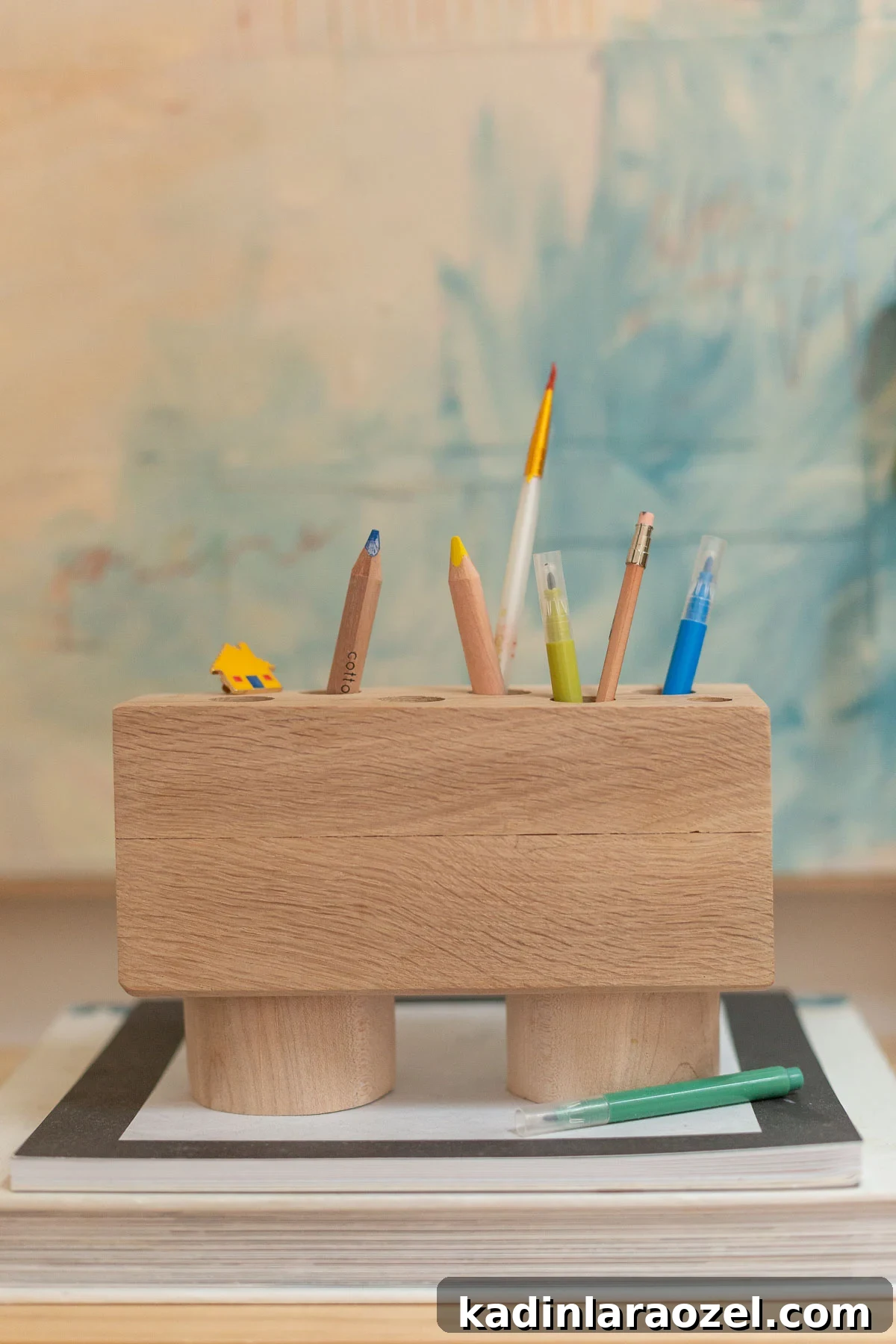 DIY Pencil Holder Makeover: Stylish Steps to Upcycle a Holder 7 Minimal wood pencil and pen holder on a desk with abstract artwork and books