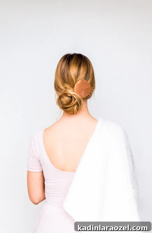 How to Create a Side-Swept Chignon: Step-by-Step Tutorial 4 Woman wearing pink dress and white shawl with hair up in low bun.