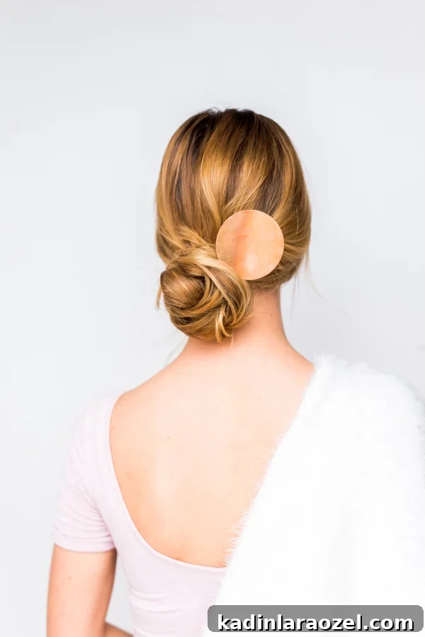 How to Create a Side-Swept Chignon: Step-by-Step Tutorial 8 Woman wearing low bun and copper hair accessory