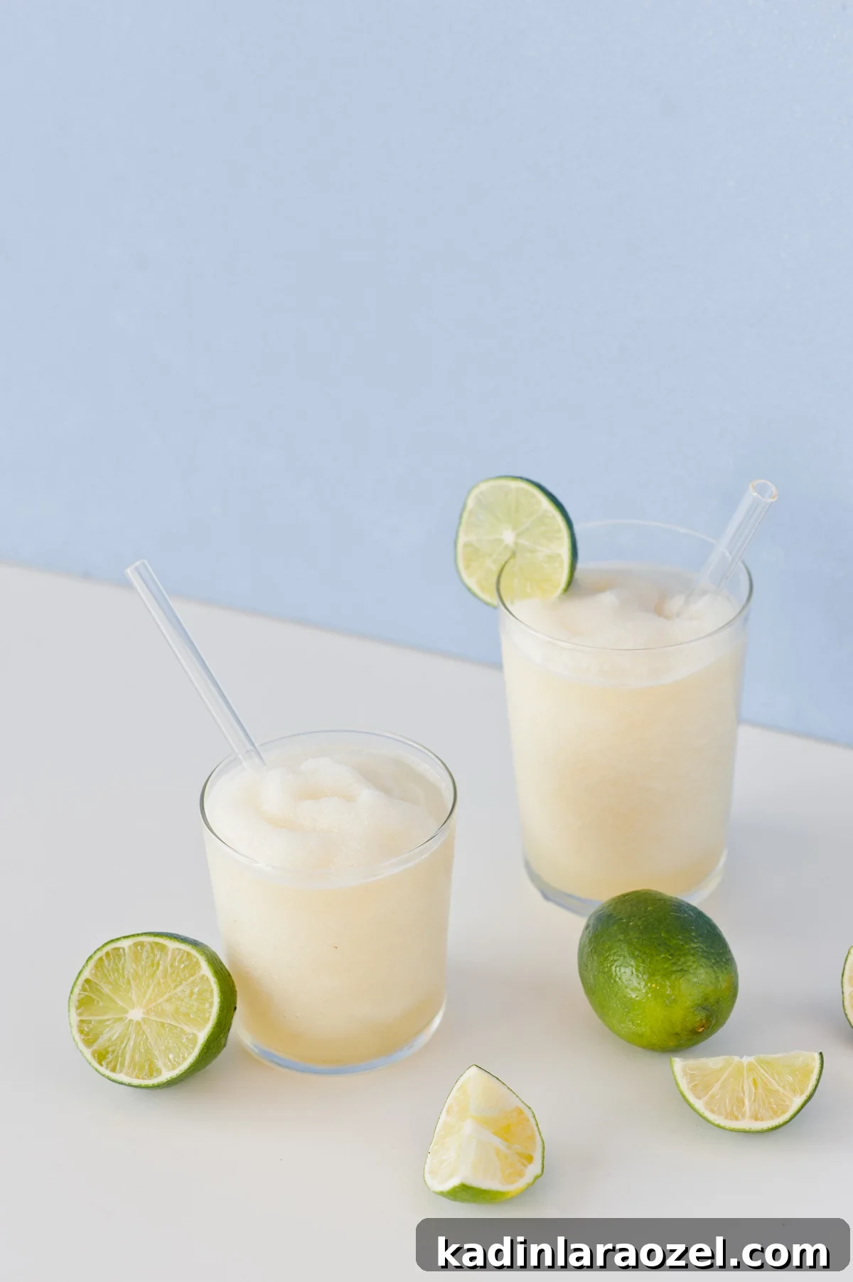 Gin and Juice Slushie Recipe: Refreshing Frozen Cocktail Guide 2 Two alcoholic slushies on a white table with blue background