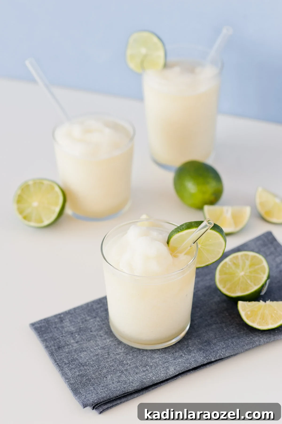 Summer cocktails with lime slices and clear glassware 