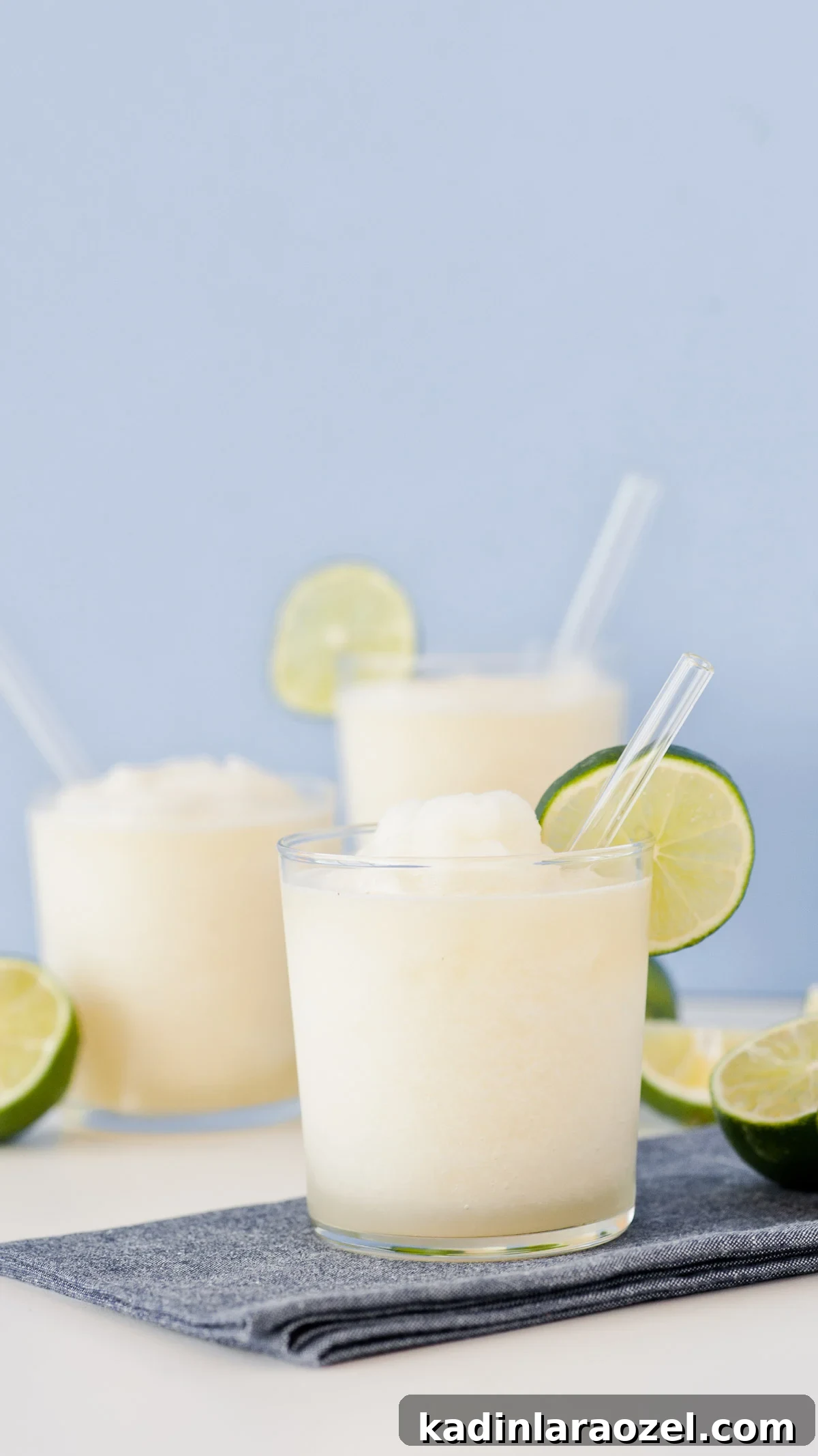 Gin and Juice Slushie Recipe: Refreshing Frozen Cocktail Guide 6 Close up on alcoholic slushie drink with thin lime wedge and glass straw