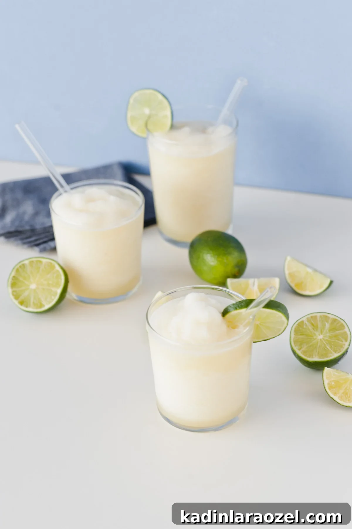 Gin and Juice Slushie Recipe: Refreshing Frozen Cocktail Guide 7 Overhead of slushie cocktails with lime slices and napkins on a white table
