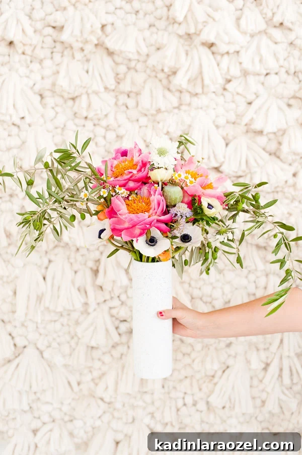 A pretty DIY bouquet of peonies, anemones, ranunculus, and olive branches.