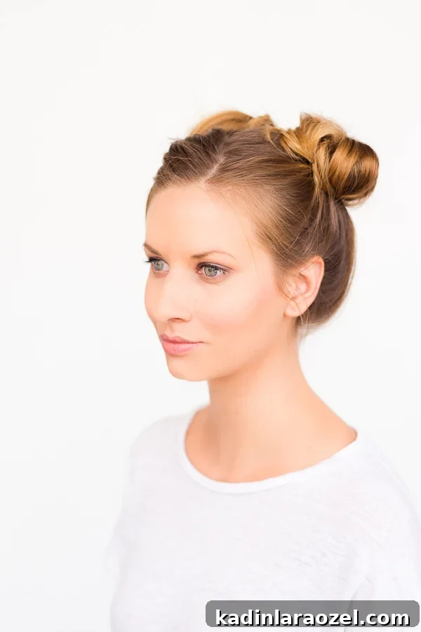 Blonde woman with hair parted down the middle and two bun pigtails in an updo