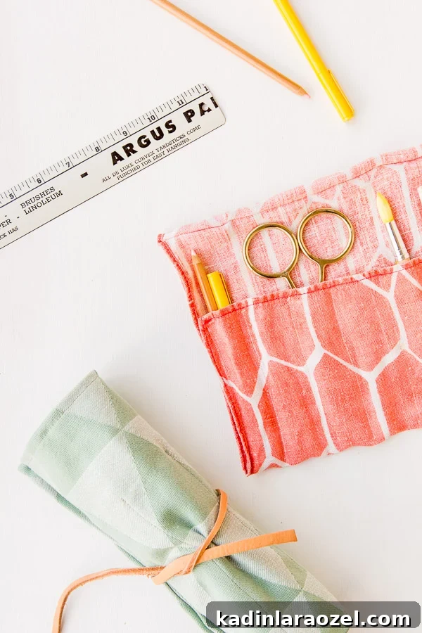 Fabric rollup office organizer with pencils and scissors inside.