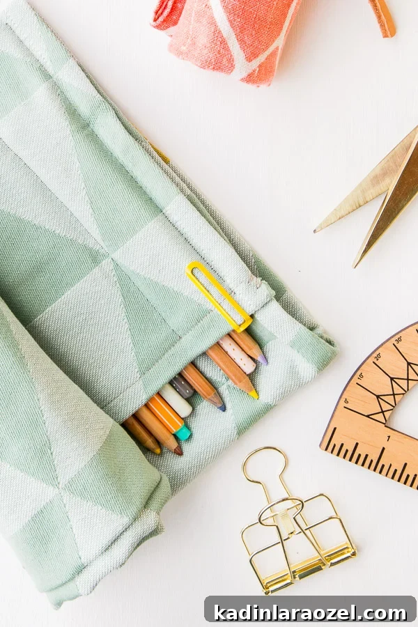 Closeup of mint green fabric pencil organizer with office supplies around it.