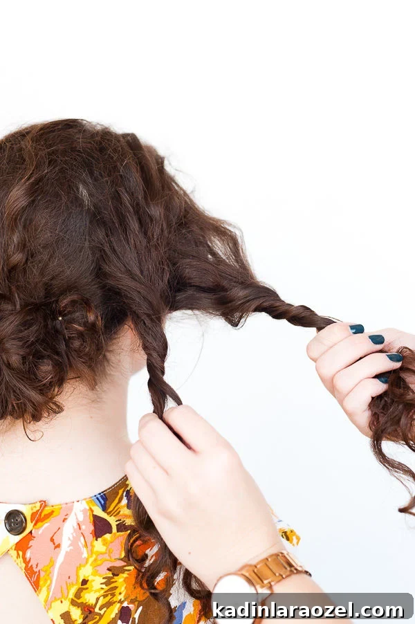 5-Minute Rope Twist Curly Updo Tutorial 5 Twisting hair in sections on brunette woman with medium length hair