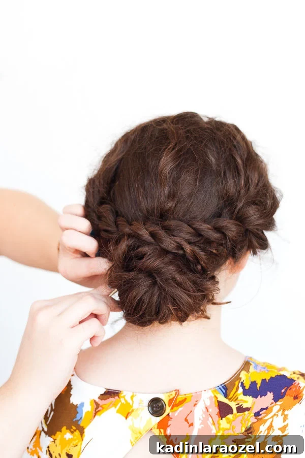 5-Minute Rope Twist Curly Updo Tutorial 9 Adding bobby-pins to woman's brunette curly hair updo