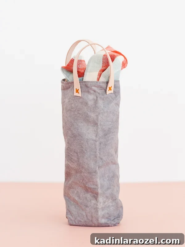 Festive DIY Canvas Wine Bags for Holiday Hostess Gifts 7 Grey canvas wine bag with leather handles, sitting on pink countertop