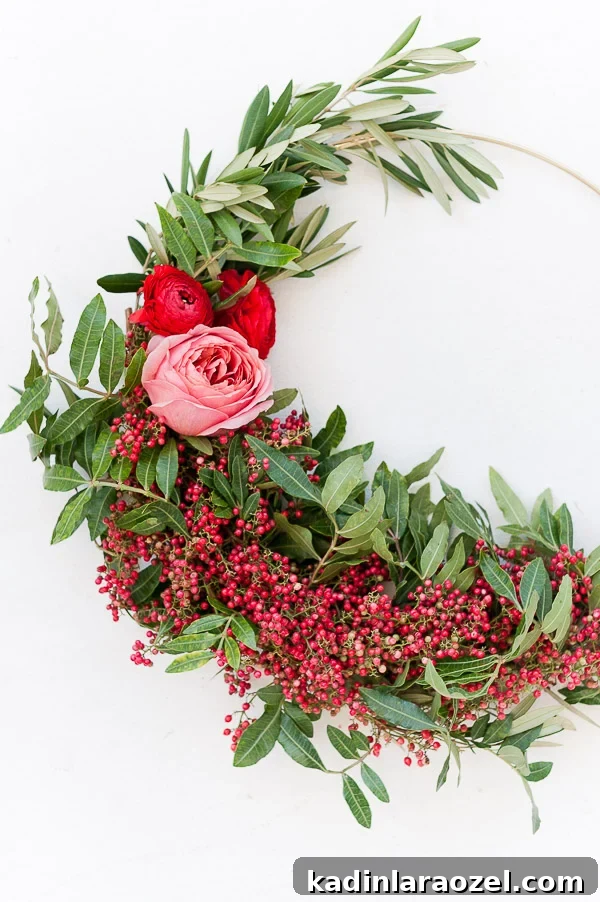Create an Asymmetrical Wreath: Step-by-Step Design Guide 13 Closeup of unique Christmas wreath with red berries and pink and red flowers