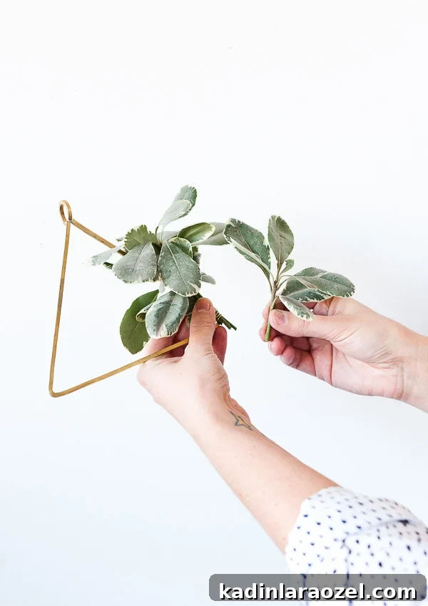 Create an Asymmetrical Wreath: Step-by-Step Design Guide 5 Woman making asymmetrical holiday wreath shaped like a triangle.