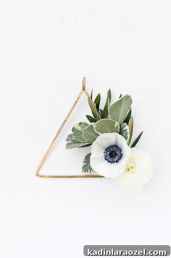 Create an Asymmetrical Wreath: Step-by-Step Design Guide 7 Gold triangle wreath with white anemones and greenery.