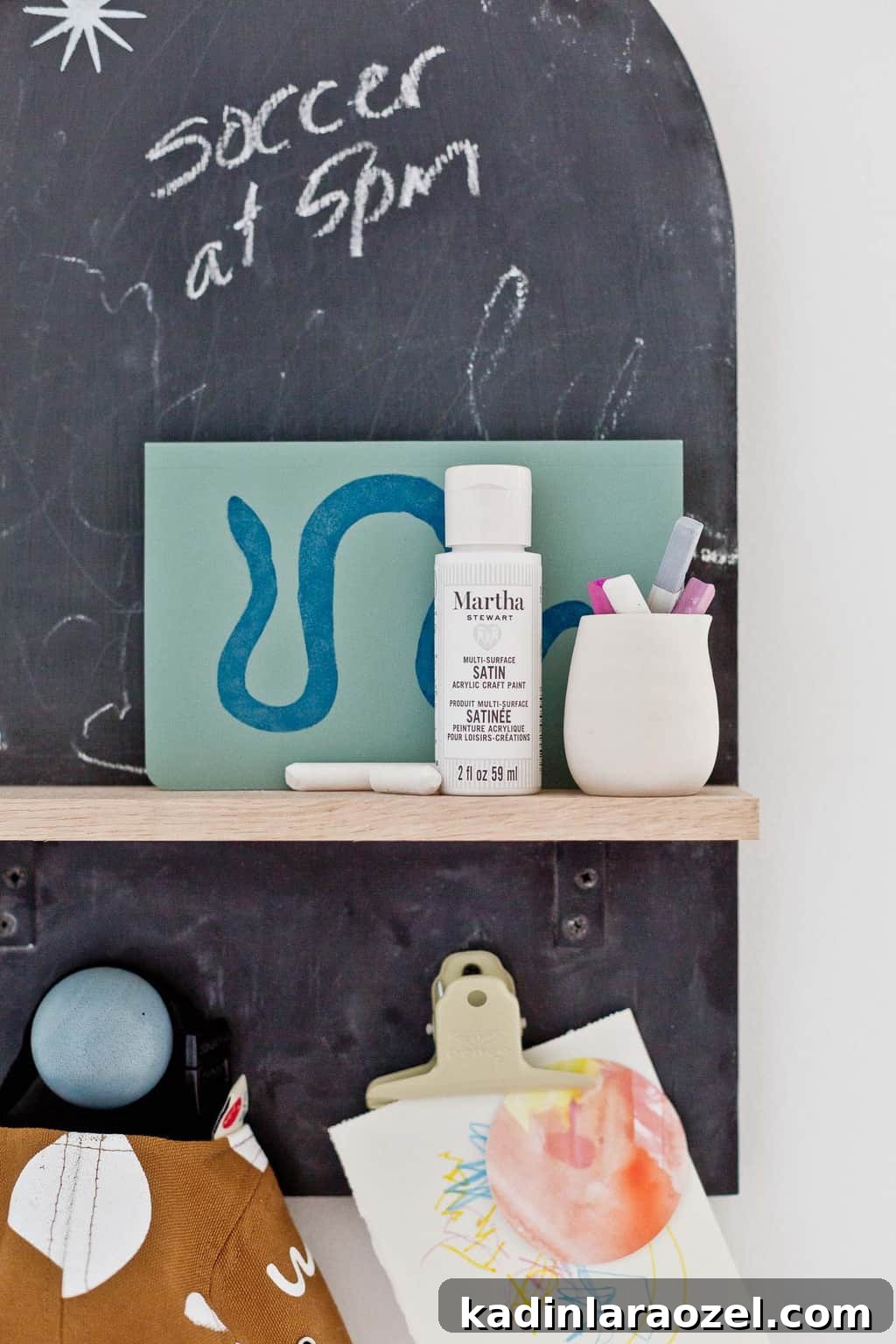 49 Clever DIY Home Organization Ideas to Maximize Space 22 Closeup details of chalkboard wall organizer for kids, with artwork and hat hanging.