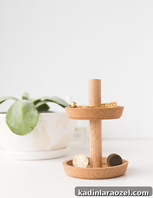 49 Clever DIY Home Organization Ideas to Maximize Space 31 A small wood and cork jewelry holder sits on a plain white table.