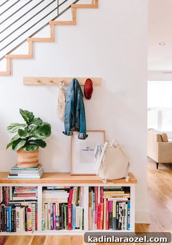 49 Clever DIY Home Organization Ideas to Maximize Space 43 A simple wood peg rail hangs on the wall, underneath the stairway of a modern home.