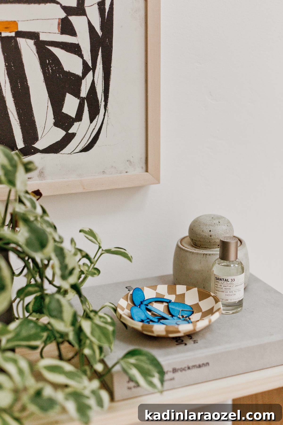 49 Clever DIY Home Organization Ideas to Maximize Space 44 Checkered clay bowl sitting on wood table with books and plants