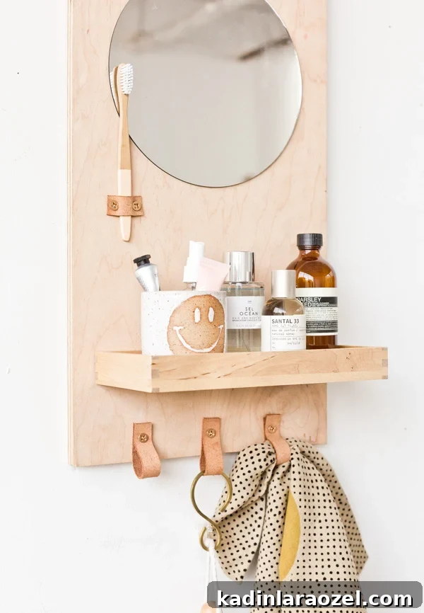49 Clever DIY Home Organization Ideas to Maximize Space 48 A wood wall organizer for the bathroom with round mirror and leather loops for towels