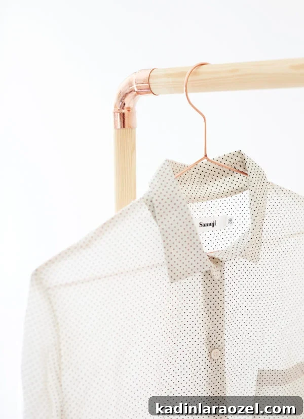 49 Clever DIY Home Organization Ideas to Maximize Space 8 DIY clothing rack made of wood dowel rods and copper piping, with shirt hanging from it