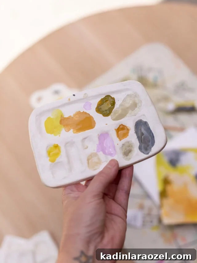 49 Creative DIY Valentine Gift Ideas for Loved Ones 19 holding up handmade paint palette in art studio
