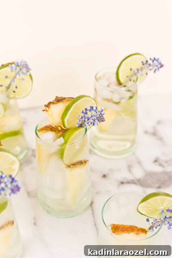 Pineapple Lime Sangria Spritzers for Spring Refreshment 2 A tropical cocktail recipe for pineapple lime sangria spritzers. Love the edible flower garnish.