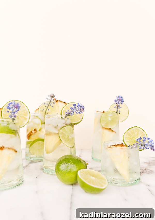 Pineapple Lime Sangria Spritzers for Spring Refreshment 4 A tropical cocktail recipe for pineapple lime sangria spritzers. Love the edible flower garnish.