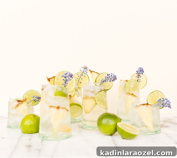 Pineapple Lime Sangria Spritzers for Spring Refreshment 6 A tropical cocktail recipe for pineapple lime sangria spritzers, with edible flower garnish.