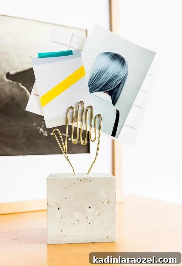 Concrete paperweight with wire hand shape to hold paperwork and photos