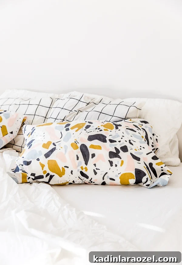 Terrazzo print standard pillowcases resting on a white linen bed with natural light