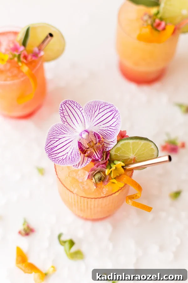 pretty pineapple mango rum punch recipe inspired by the Caribbean with fresh orchids and orange zest garnish