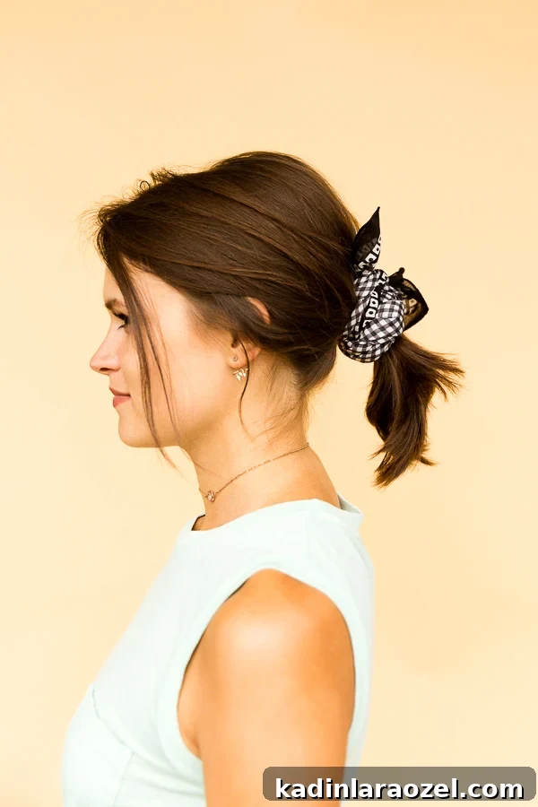 Profile of brunette women wearing a bandana in a ponytail.