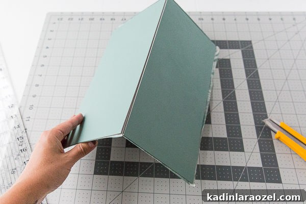 Once scored, bend the tile in half, as shown.