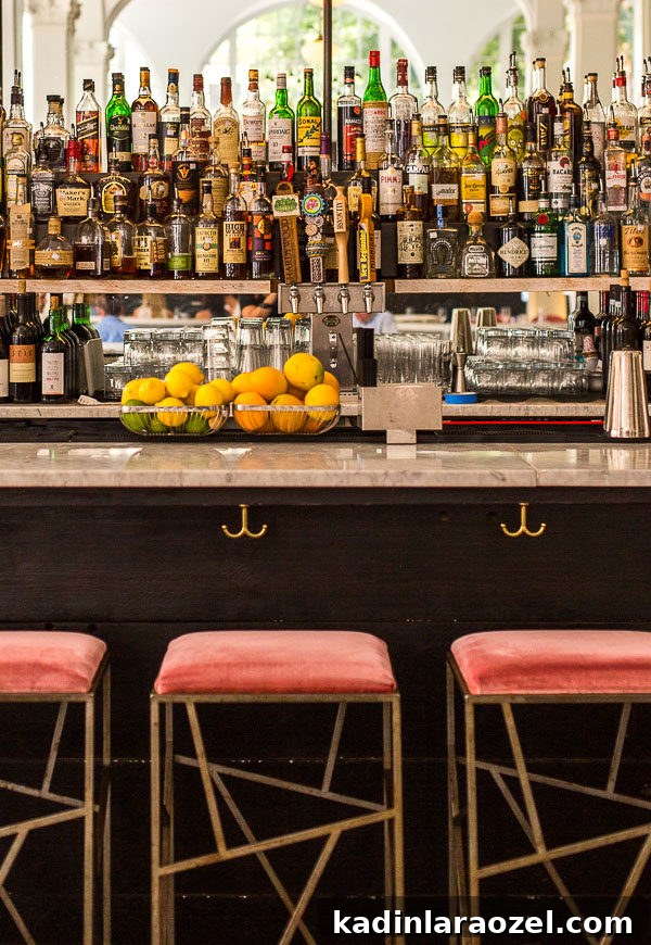 bar at Quirk Hotel in Richmond, Virginia with lined up alcohol bottles and pink velvet stools