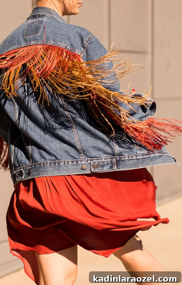 women wearing a dress and fringe jean jacket twirling around outside