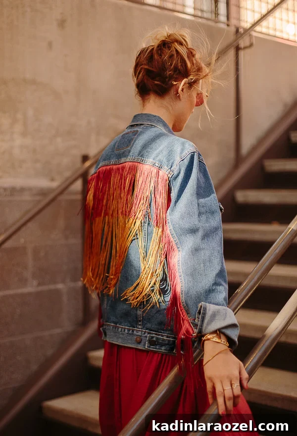 woman walking up stairs with a fringe jean jacket on