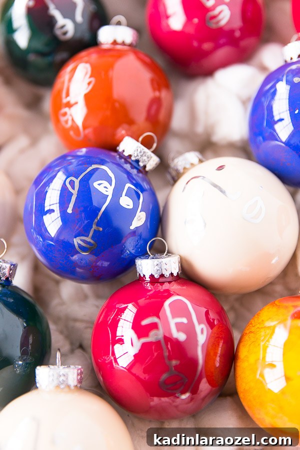 Red, blue, and orange ornaments, in a round shape, with faces drawn on them for Christmas