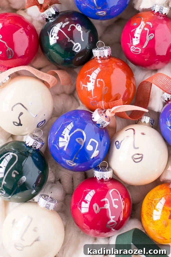 Colorful glass ornaments, in a round shape, with abstract faces drawn on them for Christmas