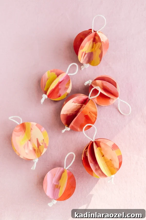 DIY Holiday Ornaments: A Complete Guide to Stylish Decorations 12 Image of paper globe ornaments in warm colors, on pink background.