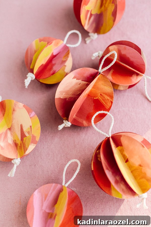 DIY Holiday Ornaments: A Complete Guide to Stylish Decorations 7 Colorful paper ornaments in a ball shape with painted surfaces in warm colors.