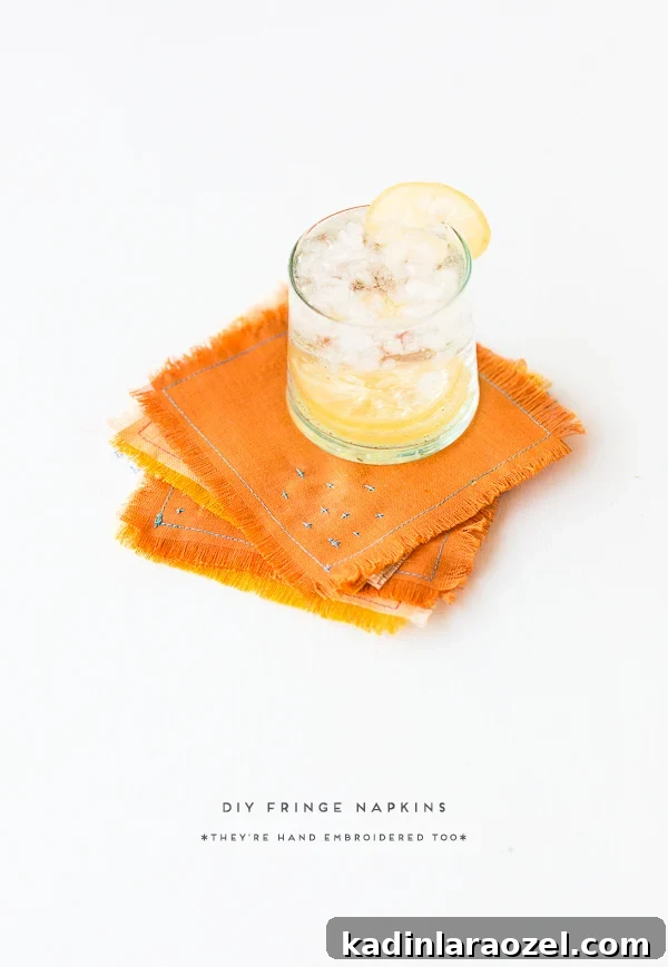Linen fabric napkins in orange and yellow with blue embroidered thread detail