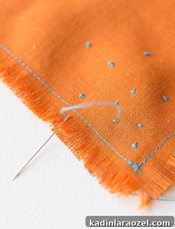 embroidering tiny designs on colorful fabric cocktail napkins