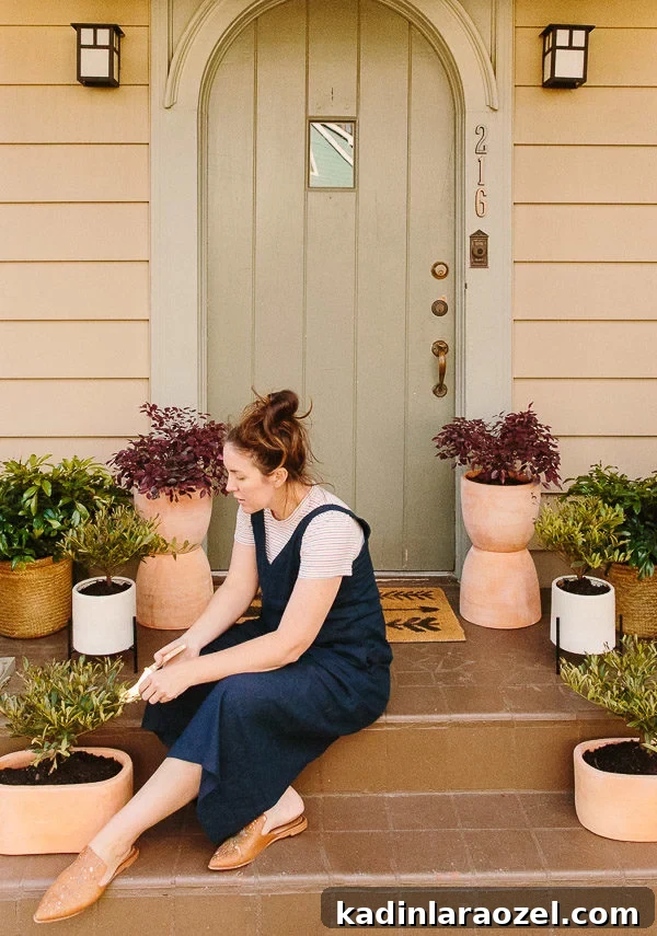 Spring Porch Plant Ideas & DIY Totem Planters for Small Spaces 2 Image of woman sitting on small front porch with plants