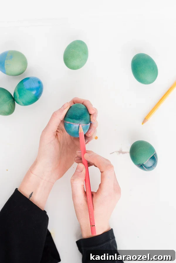 woman painting Rothko inspired Easter eggs in cool colors of green and blue