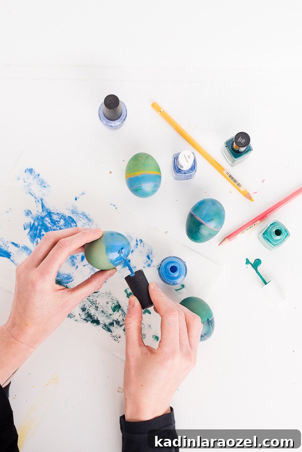 Painting Easter eggs with nail polish on a white table