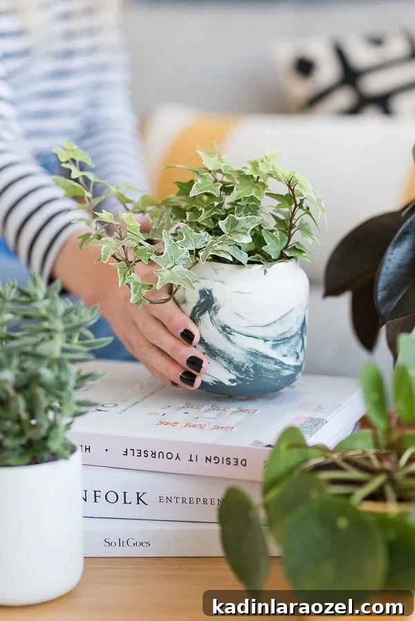 Marbled planter that was once a candle holder, sitting on coffee table with books and other plants.