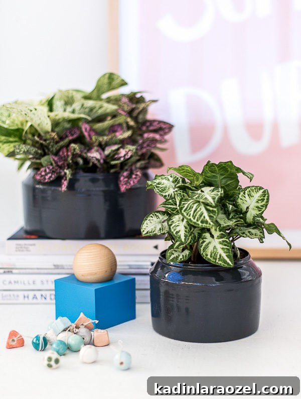 Fresh charcoal spray paint on an old tin planters that sits on a desk with books and artwork.
