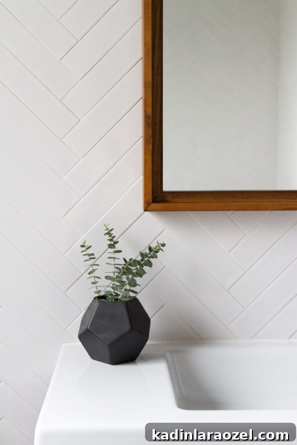 Minimal modern bathroom with white tile and eucalyptus
